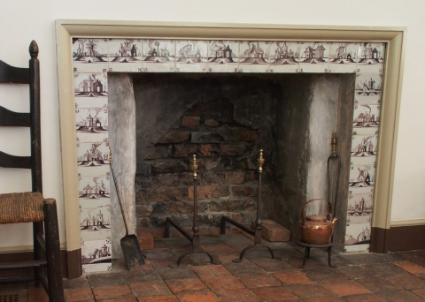 purple Delft tiles surround the open fireplace